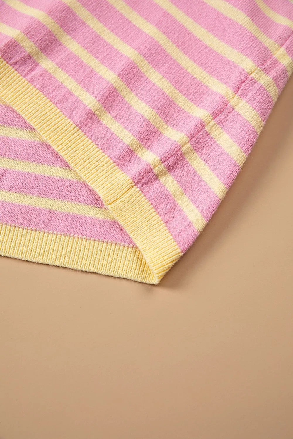Pink and yellow striped button-detail sweater, hem detail
