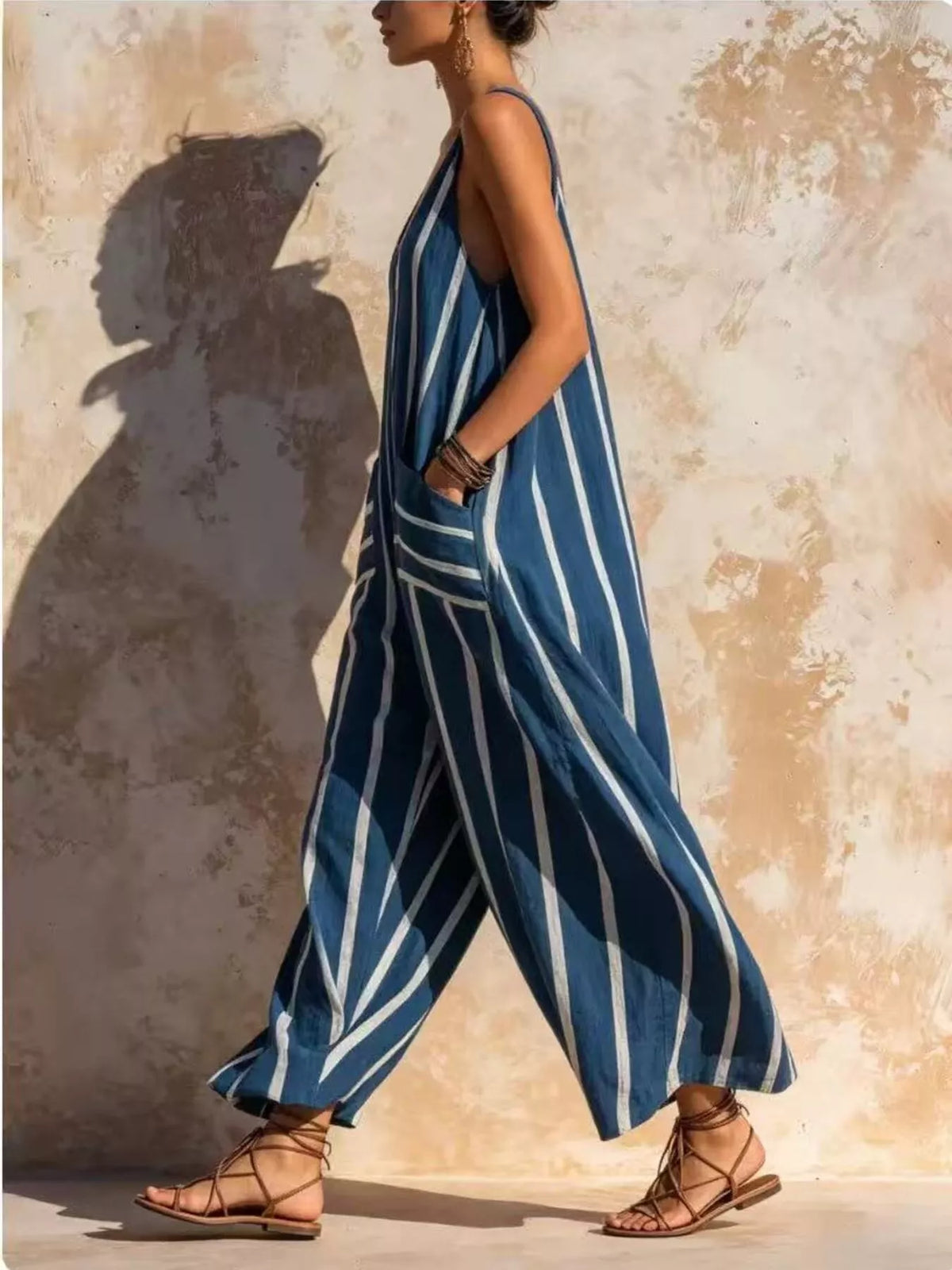 Blue and white striped sleeveless jumpsuit, side walking view