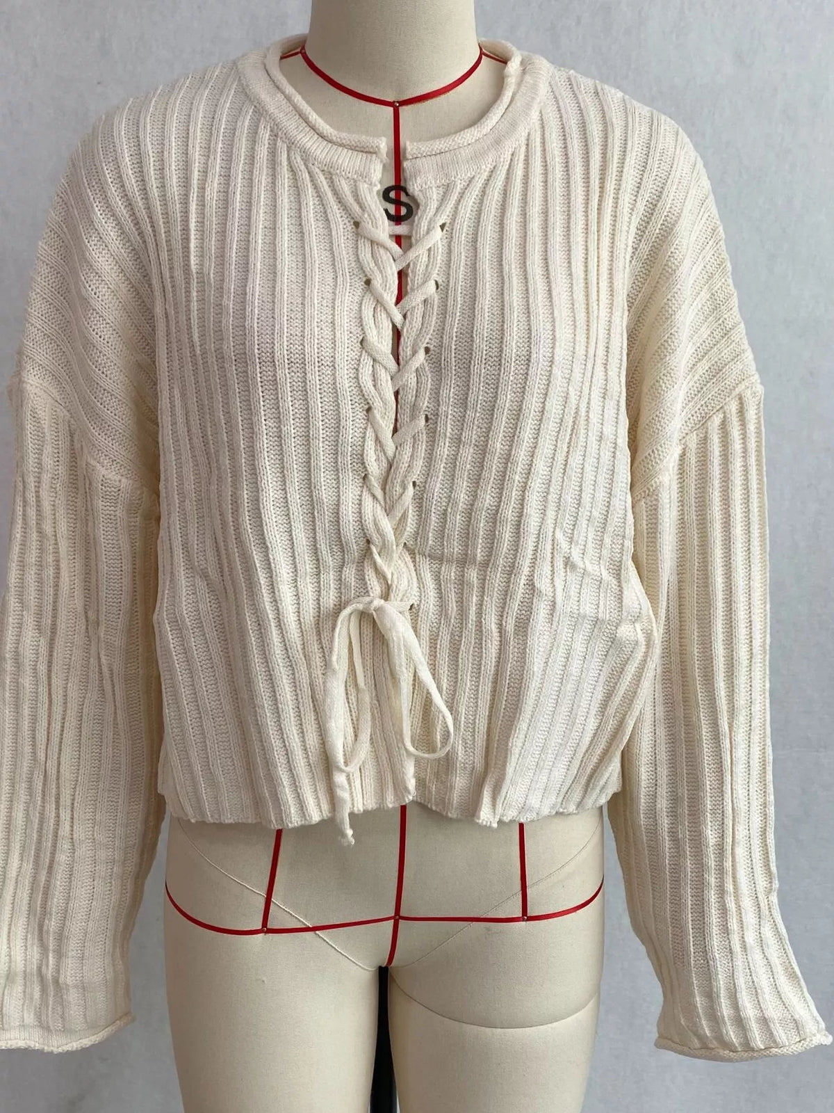 Ivory ribbed lace-up cropped sweater, front on dress form.
