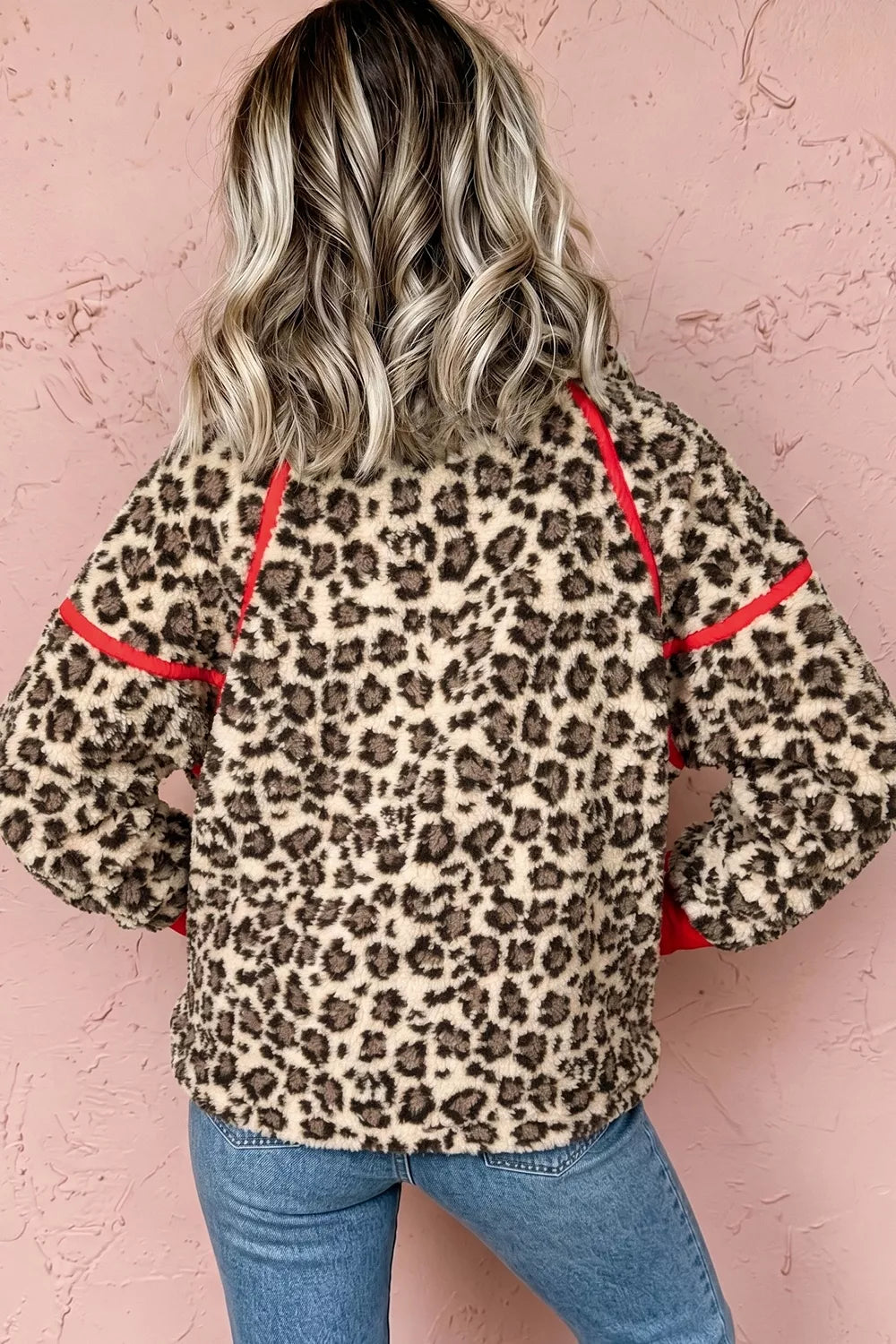 Leopard leopard half-zip sweatshirt with red trim, back view with jeans.