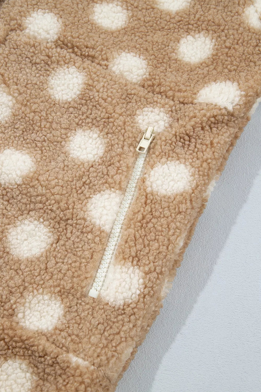 Tan and white polka dot faux fur button-front jacket with zip pockets, zip pocket detail