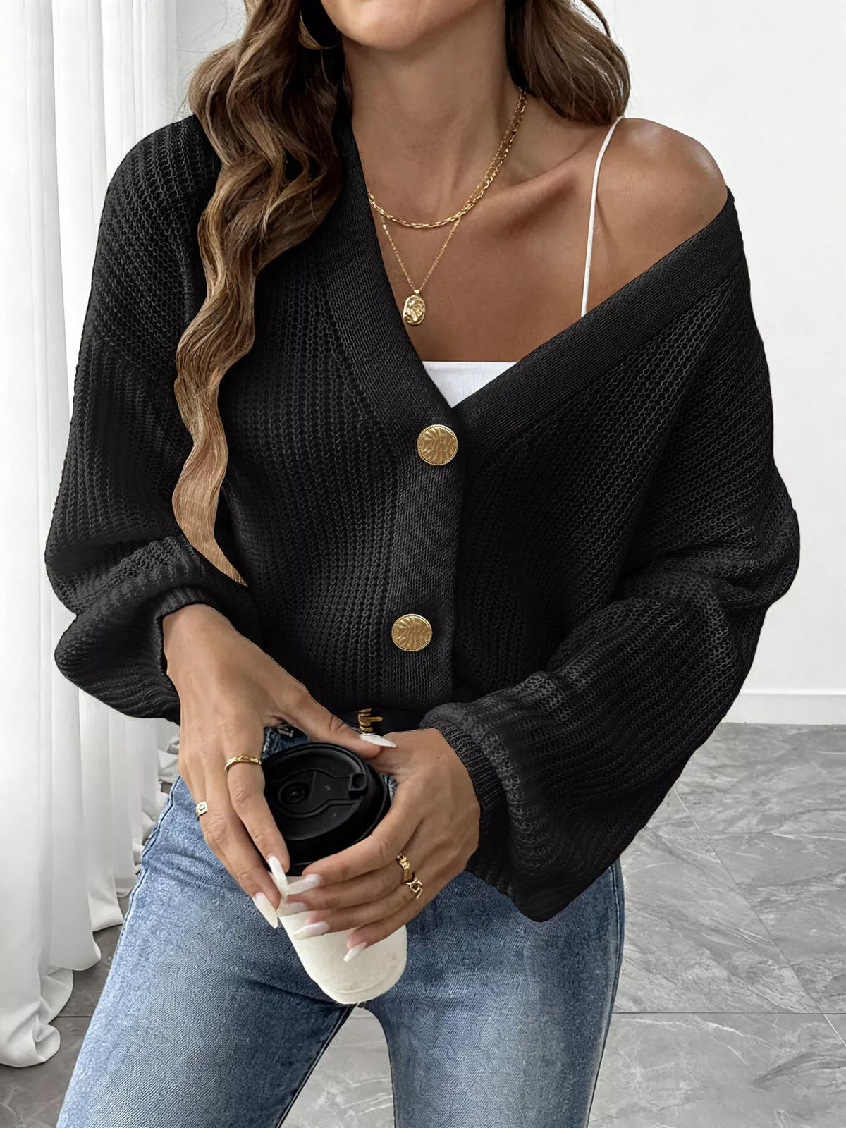 V-neck ribbed knit cardigan in black, front view worn off one shoulder