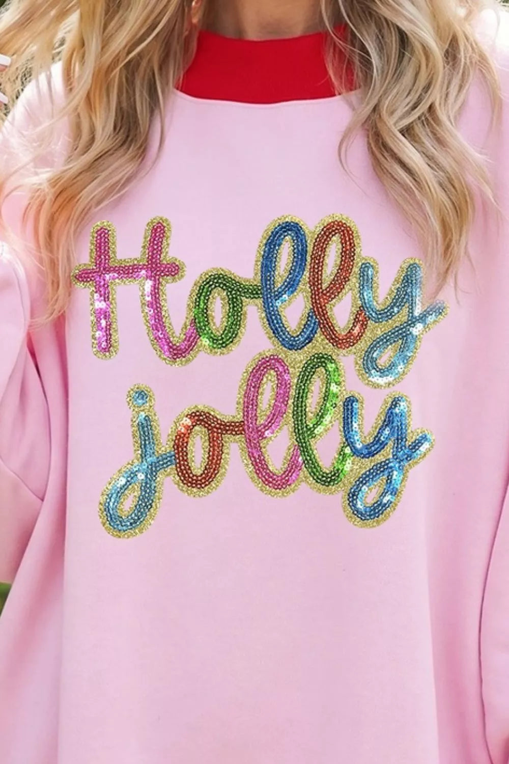 Pink Holly Jolly sequin sweatshirt with red ribbed trim, sequin lettering detail