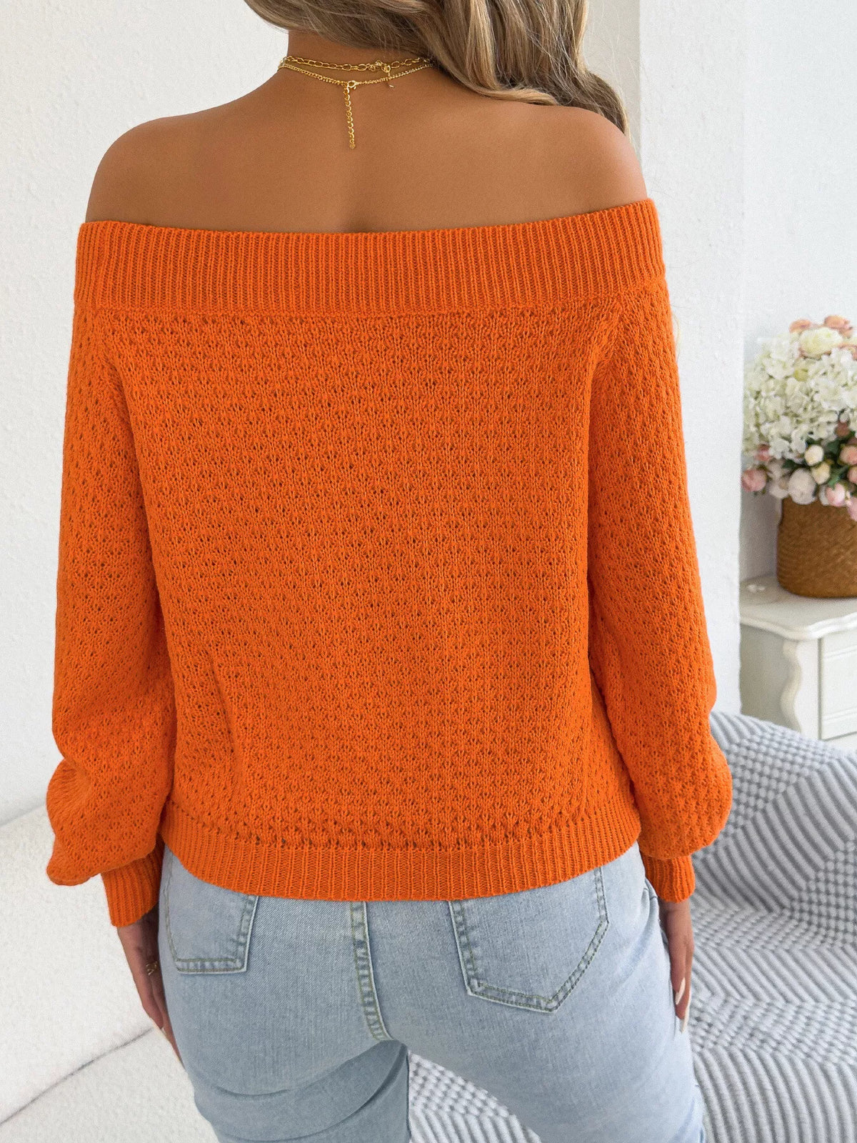 Orange off-shoulder twist-front knit sweater, back view.