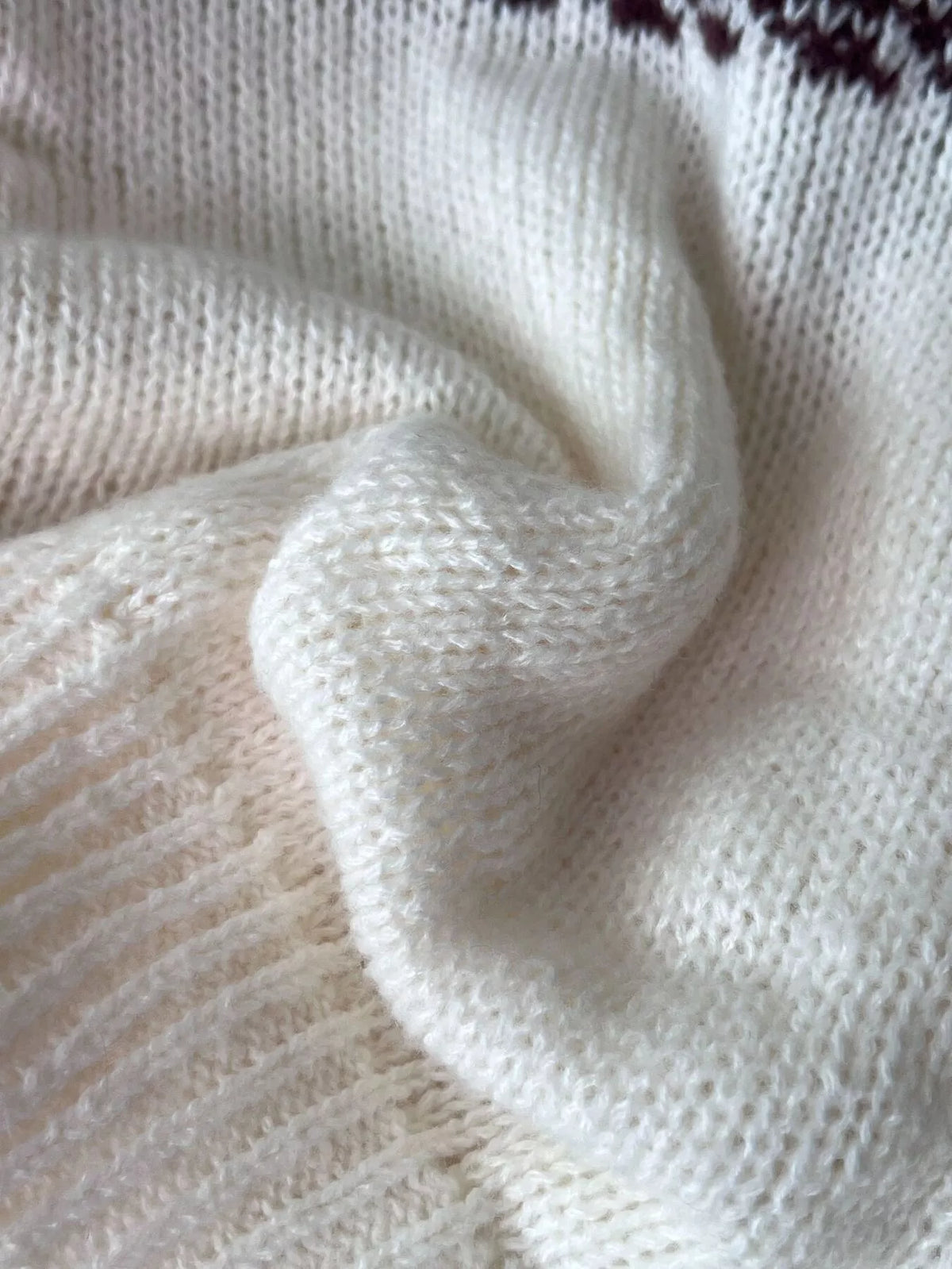 Cream fair isle round-neck sweater, knit fabric close-up.