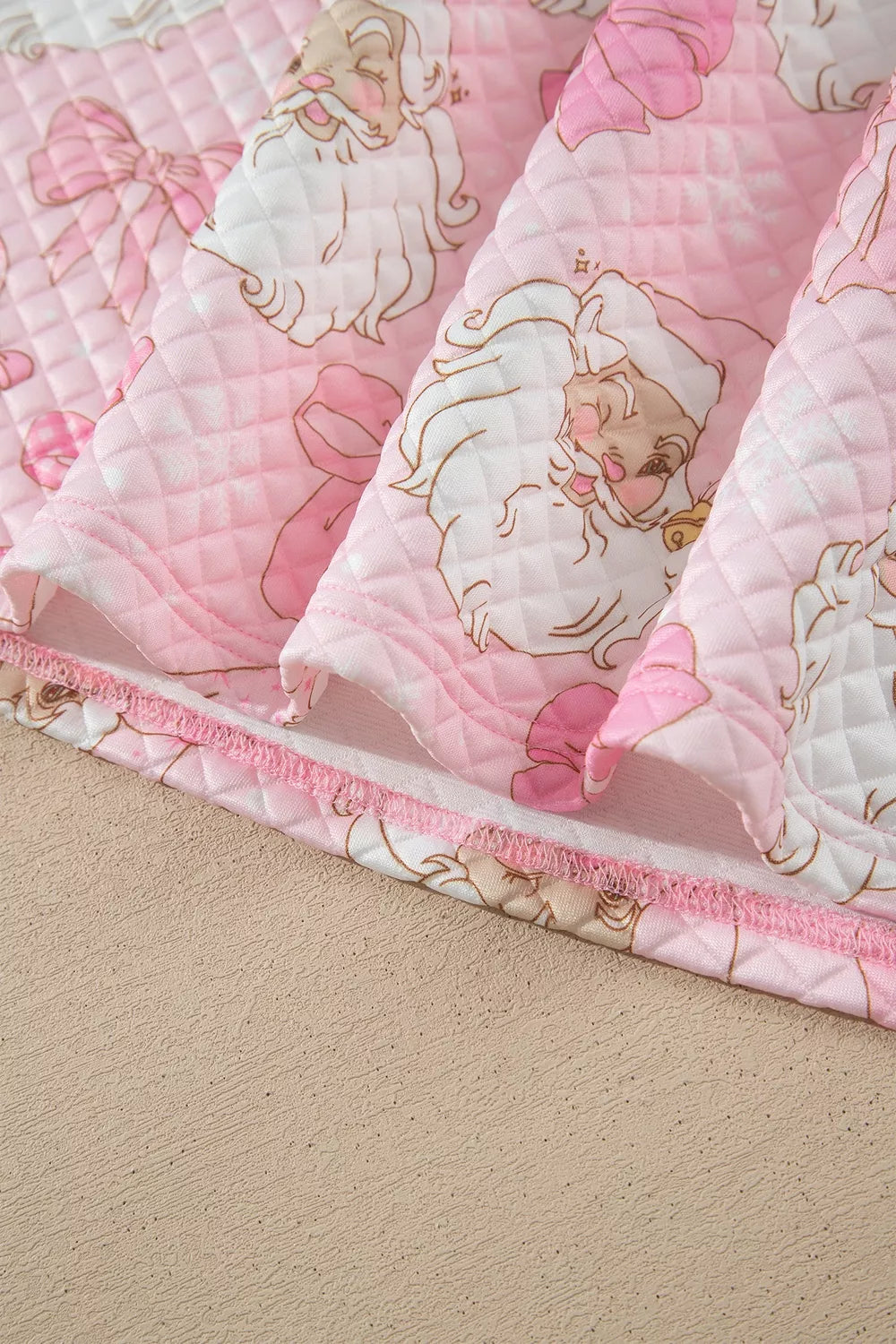 Quilted hem stitching on pink santa print christmas print quarter-zip sweatshirt