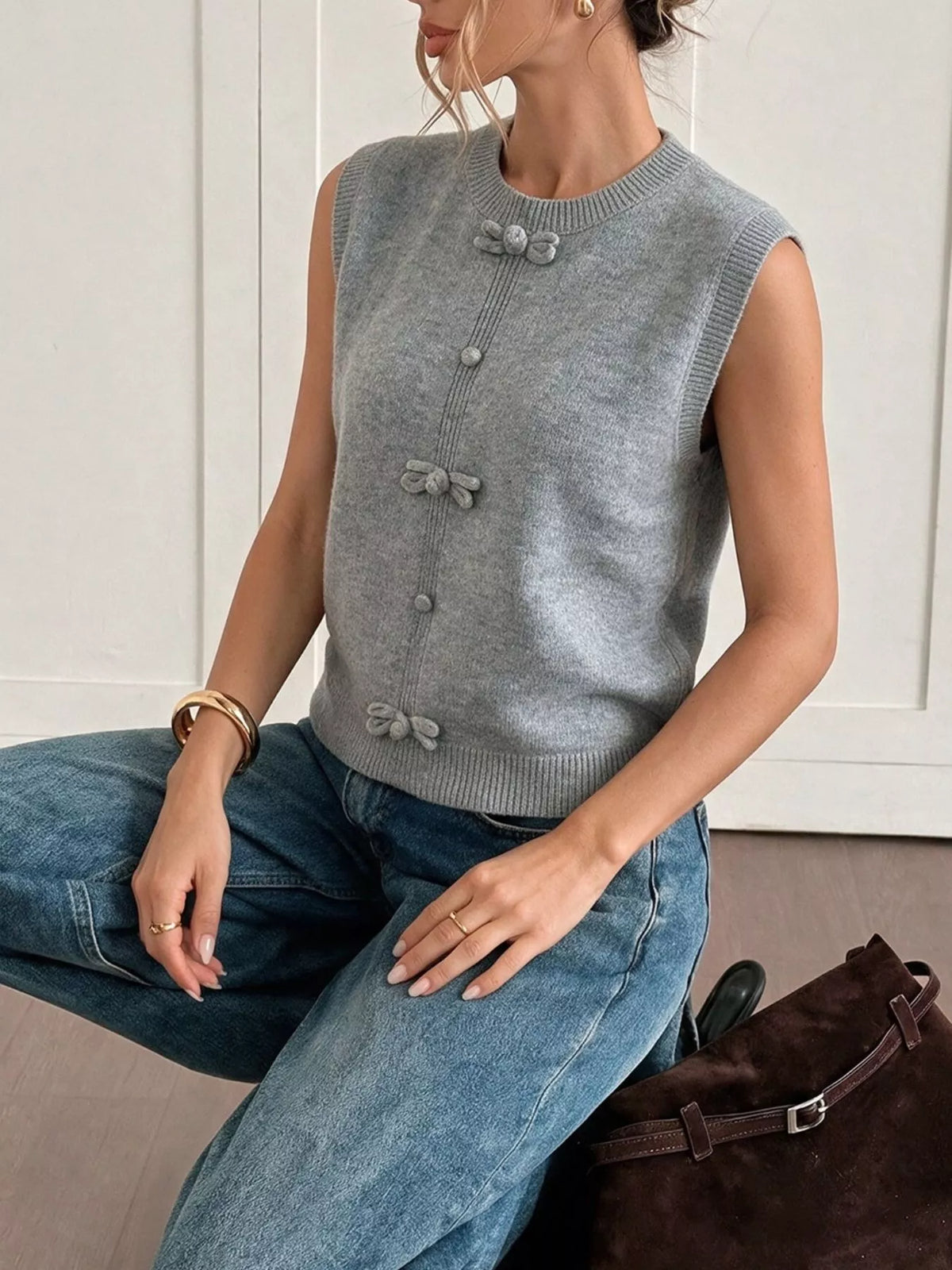 Gray bow-detail knit sweater vest, seated front view