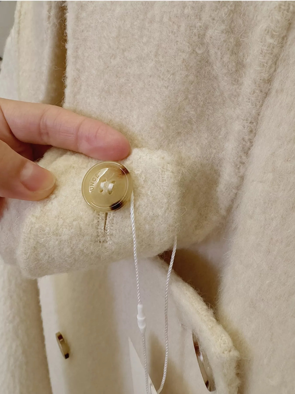 Cream double-breasted wool-blend coat — design and construction details