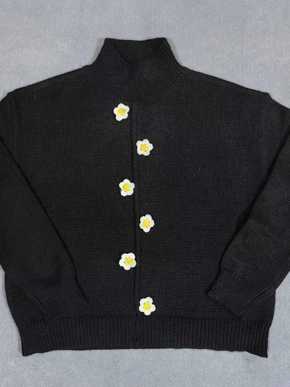 Black floral applique mock-neck sweater, front flat lay.