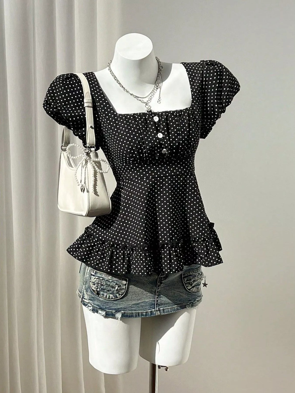 Polka-dot peplum blouse, black mannequin front