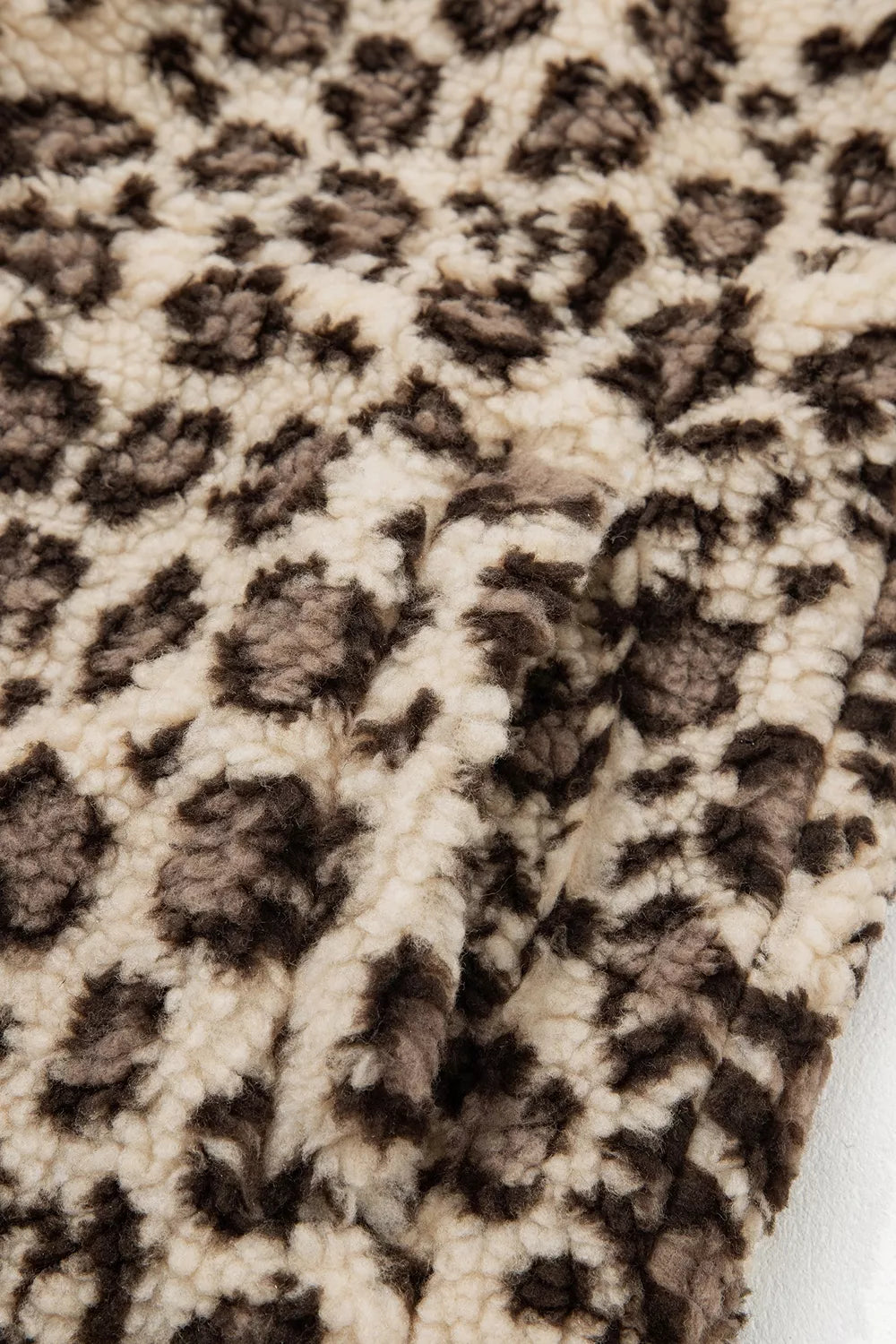 Leopard leopard half-zip sweatshirt with red trim, fabric close-up.