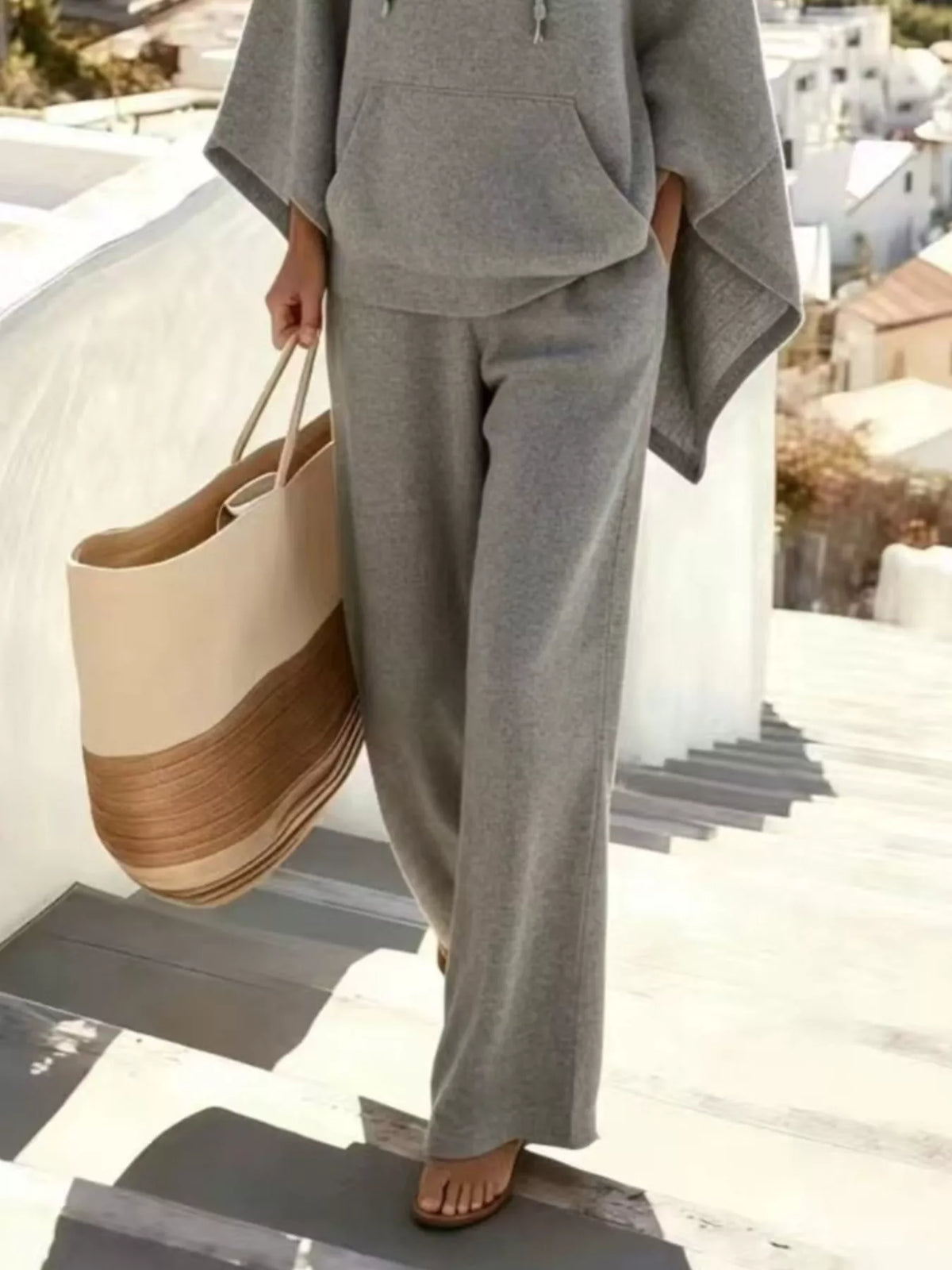 Gray hooded poncho and wide-leg pants set, pants and poncho hem detail.