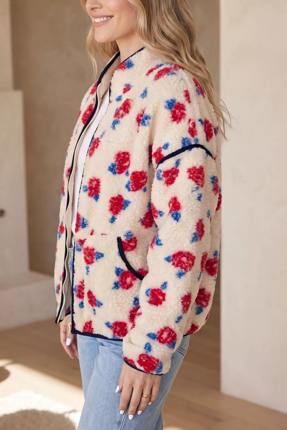 Cream with red flowers floral zip-up fleece jacket, side view.