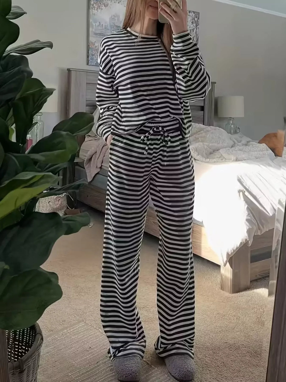 Black striped long-sleeve top and pants set, front view with raised sleeve