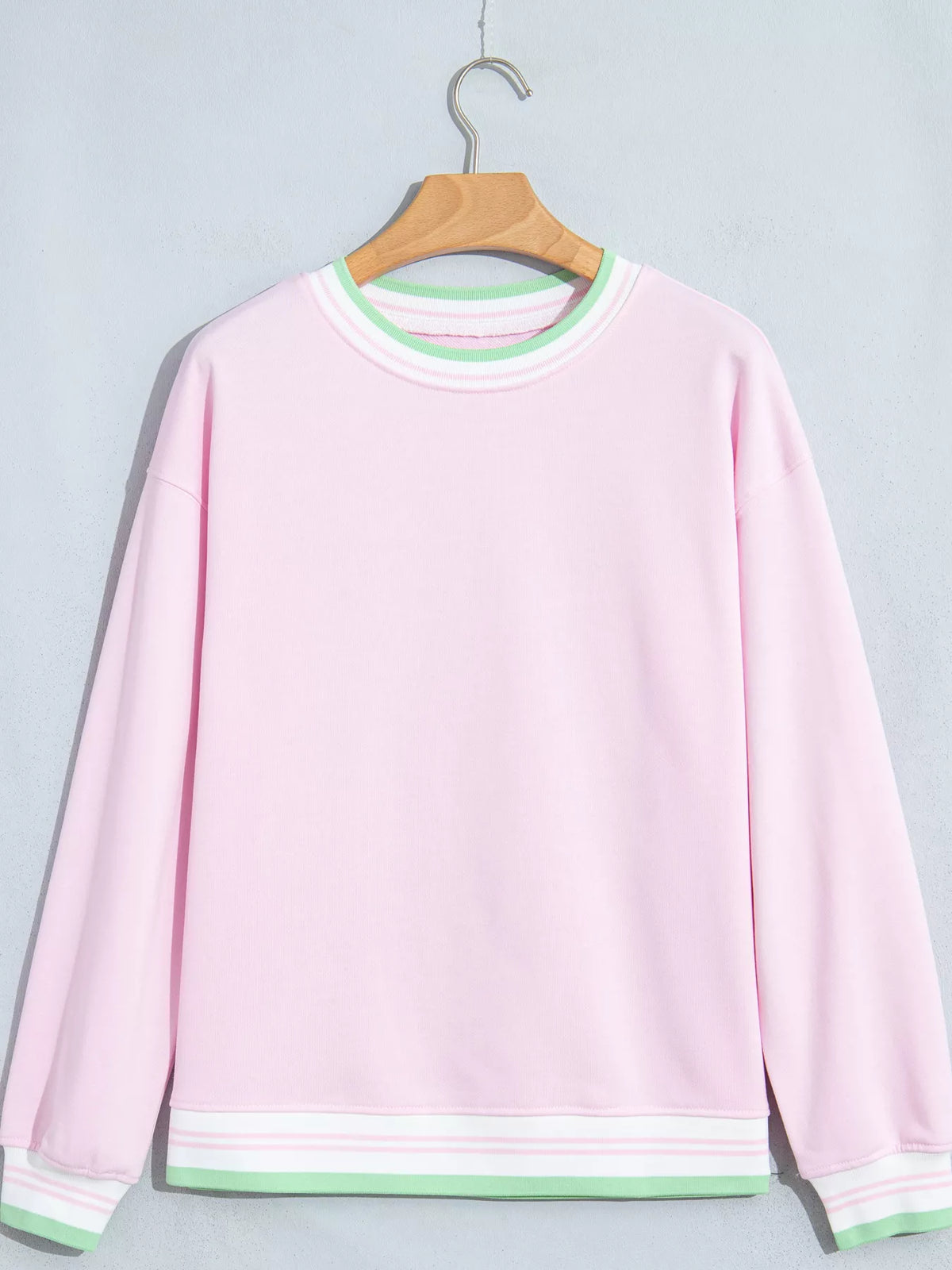 Pink sweatshirt with contrast striped ribbed trim, front view