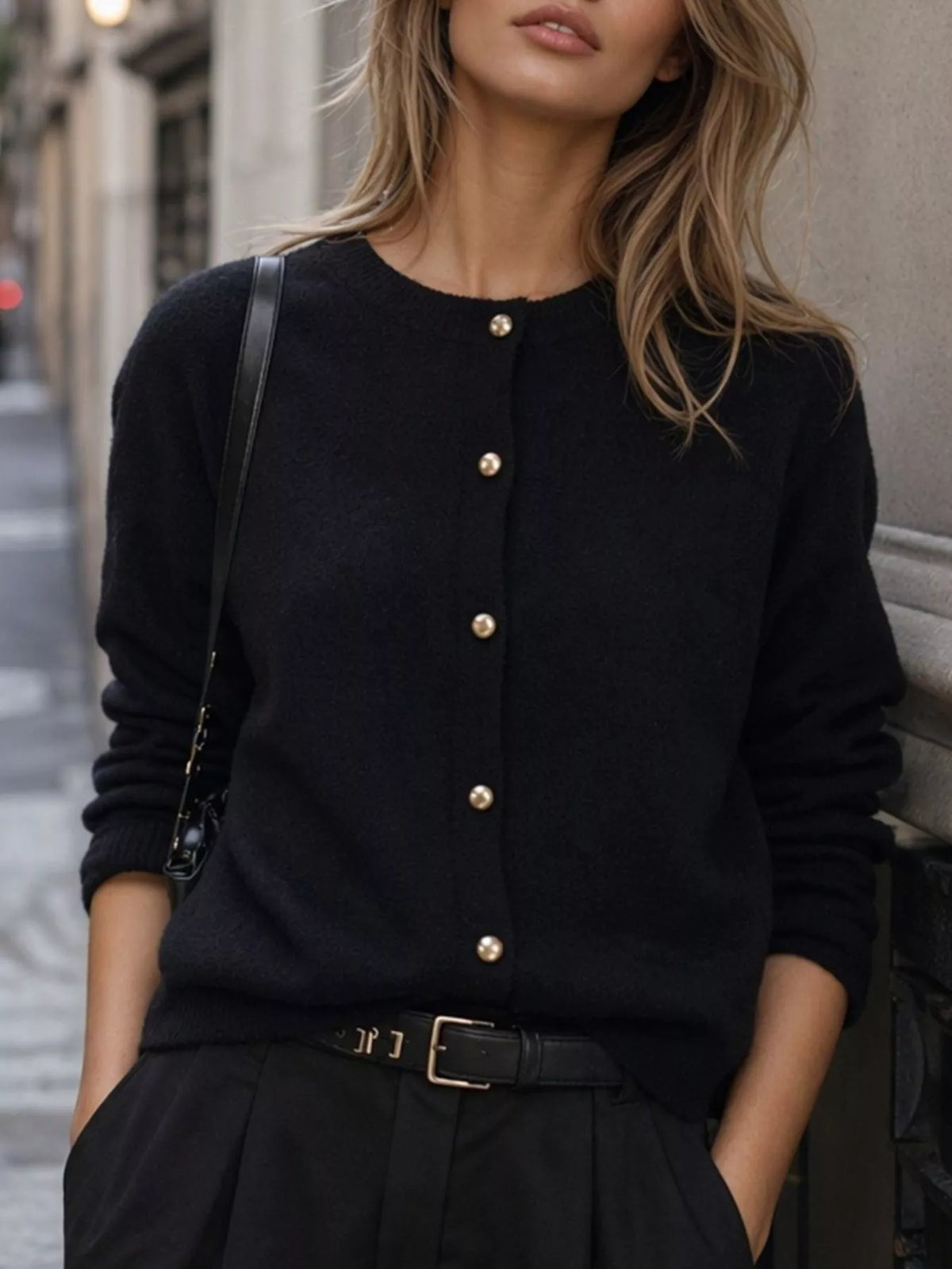 Black round-neck button-front knit cardigan, front detail.
