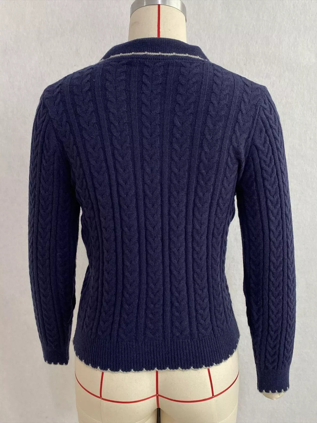Navy cable-knit polo-collar cardigan, back on dress form.
