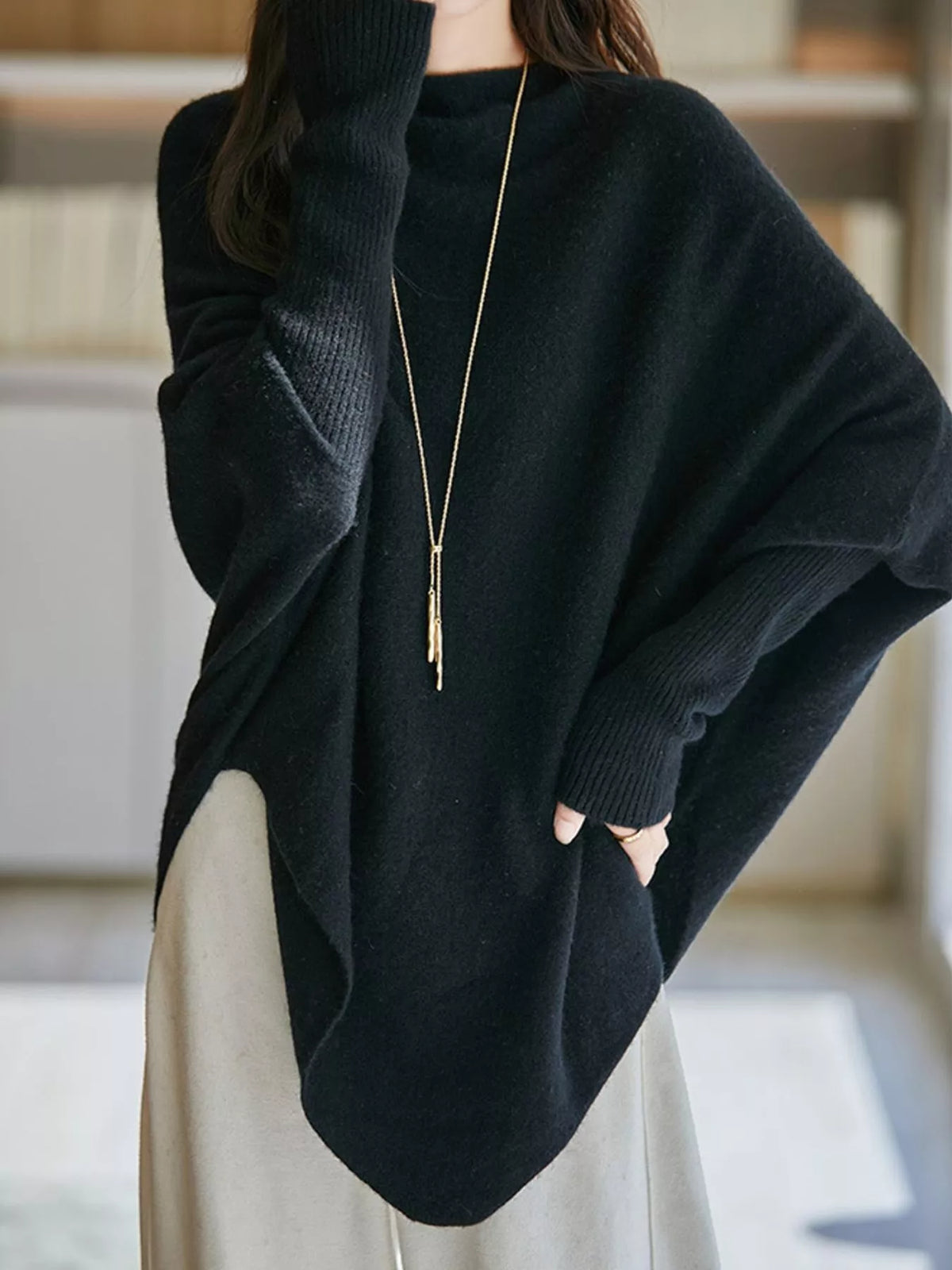 Black asymmetrical lantern sleeve sweater — front view