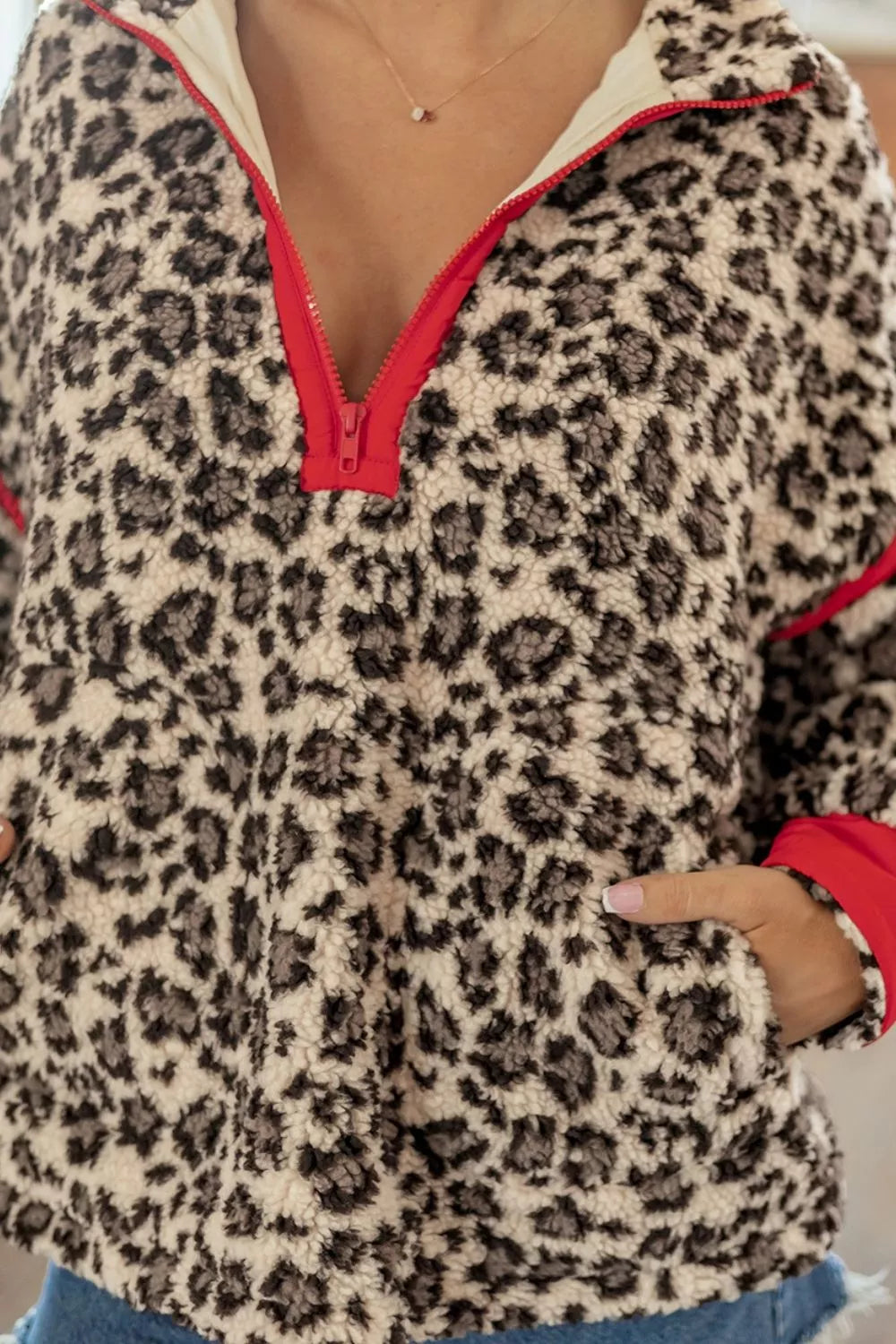 Leopard leopard half-zip sweatshirt with red trim, half-zip and pocket detail.