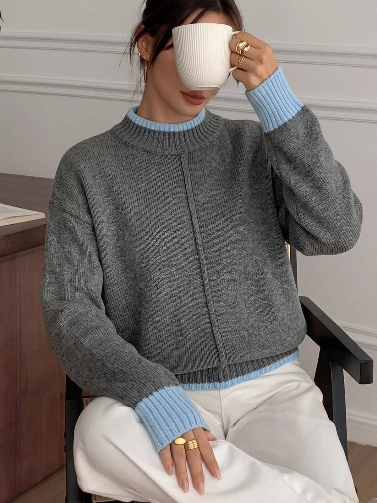 Gray sweater with blue contrast trim, front seated view