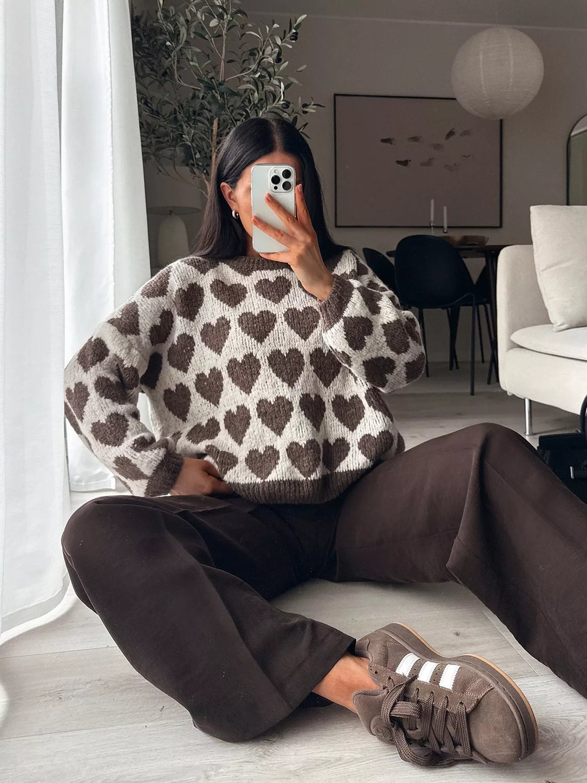 Cream and brown allover heart dropped-shoulder sweater, seated front view.