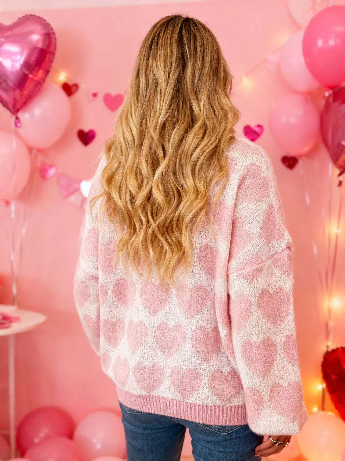 Pink and white allover heart dropped-shoulder sweater, back view.