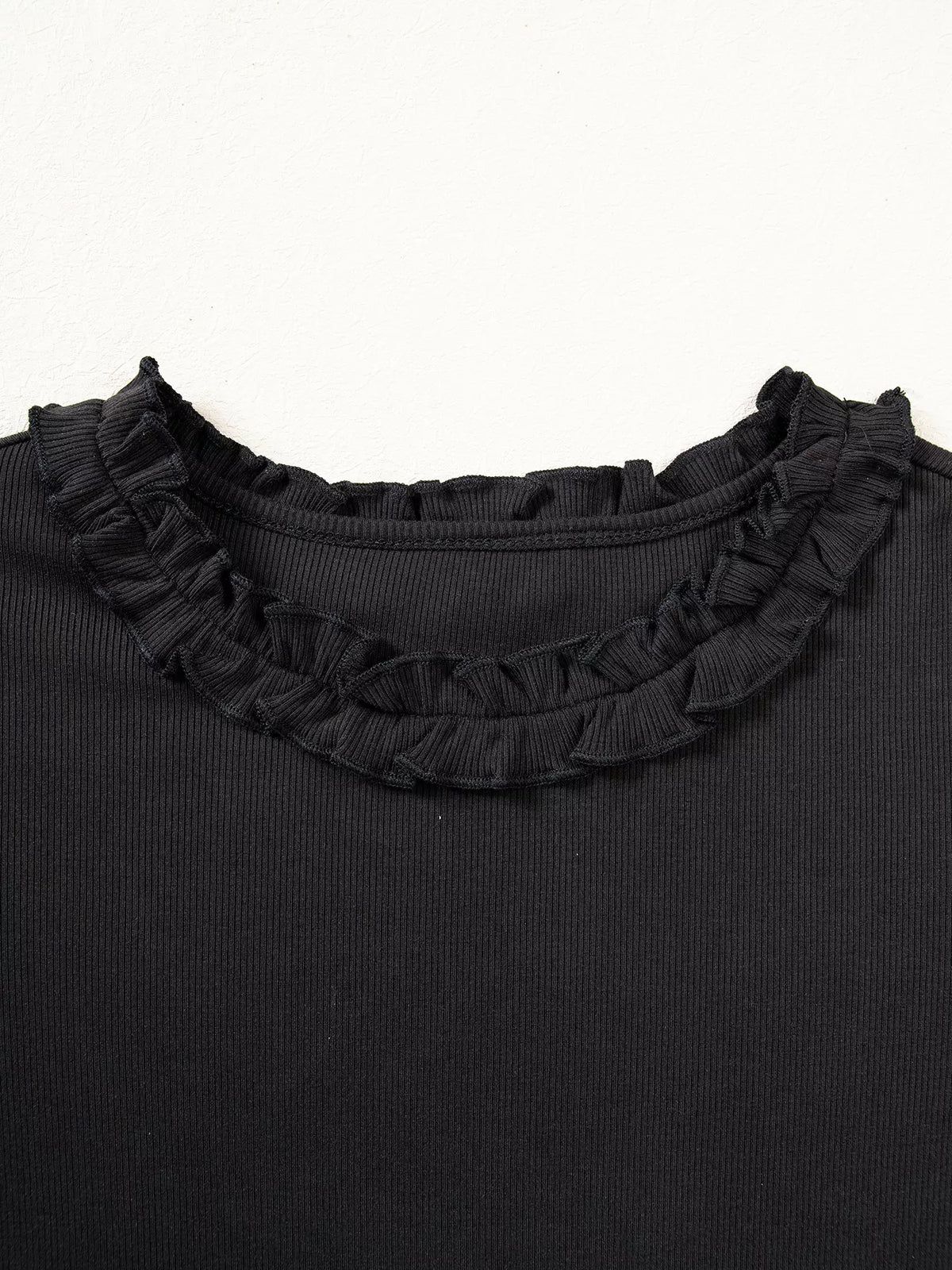 Ruffled front neckline on black round neck frill detail long sleeve top