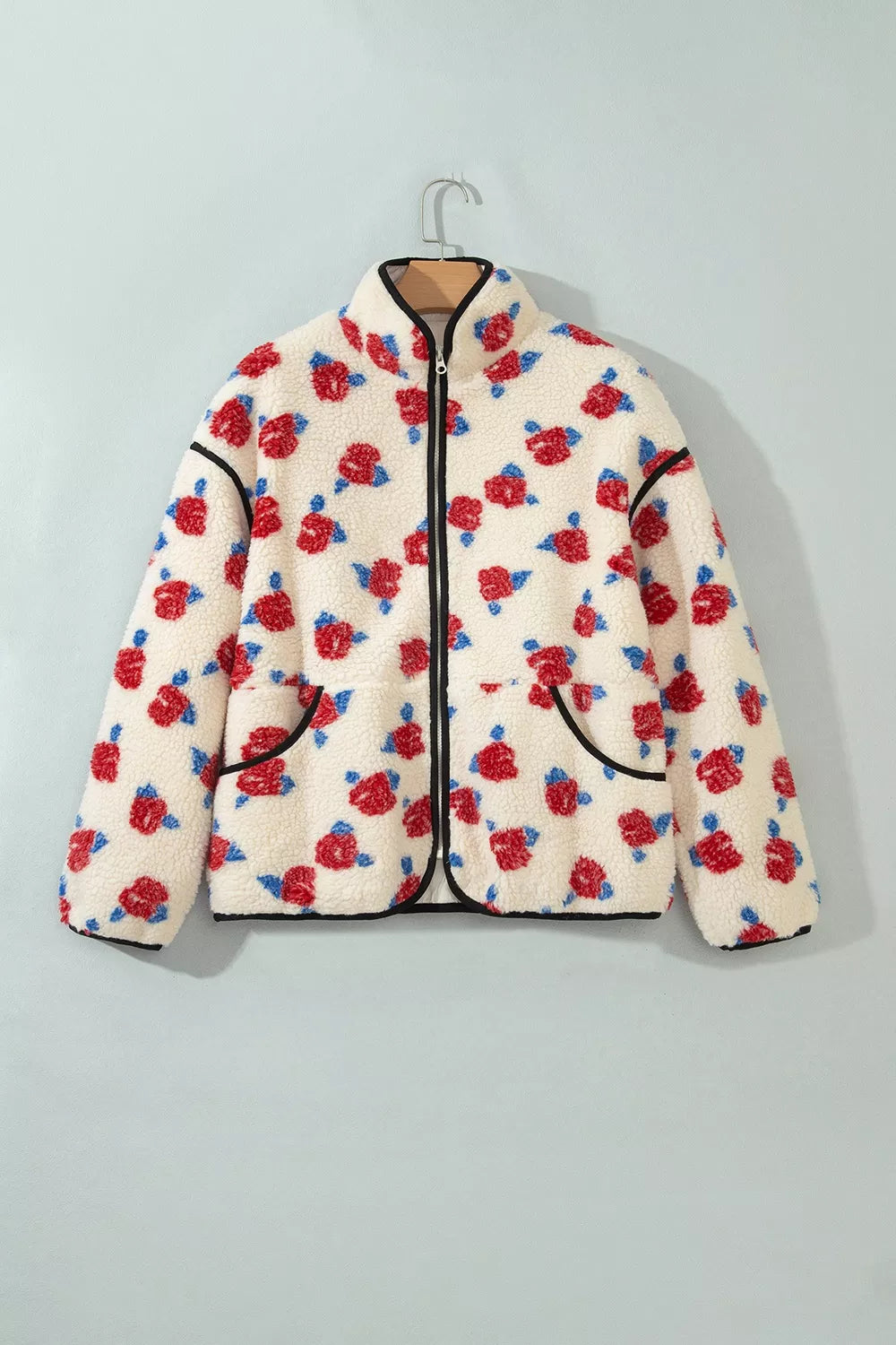 Cream with red flowers floral zip-up fleece jacket, front on hanger.