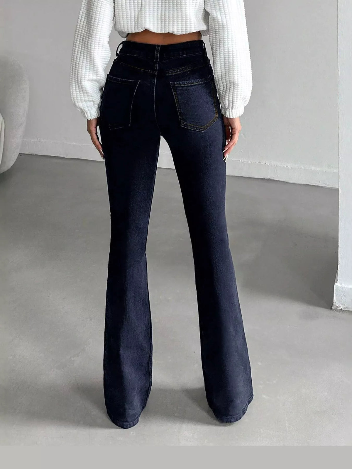 Black high-waisted slim-fit flared jeans, back view
