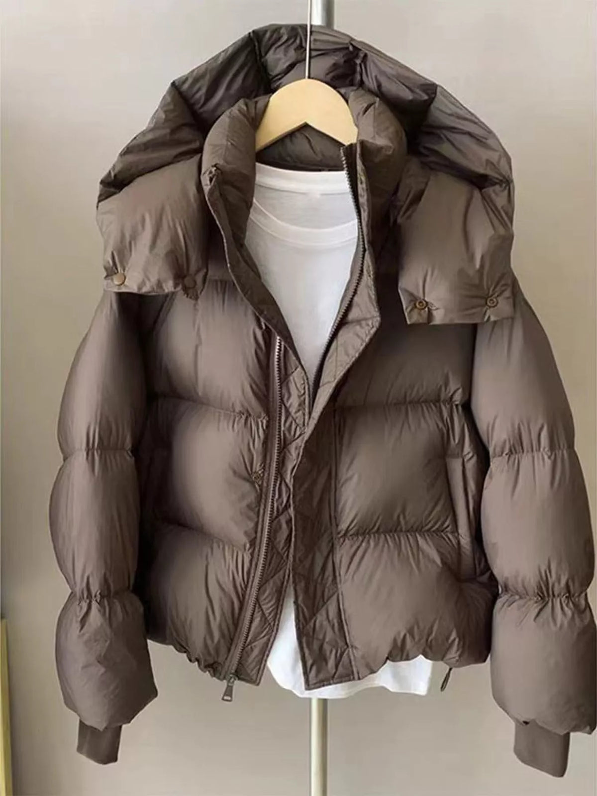 Taupe quilted hooded puffer jacket, front on hanger