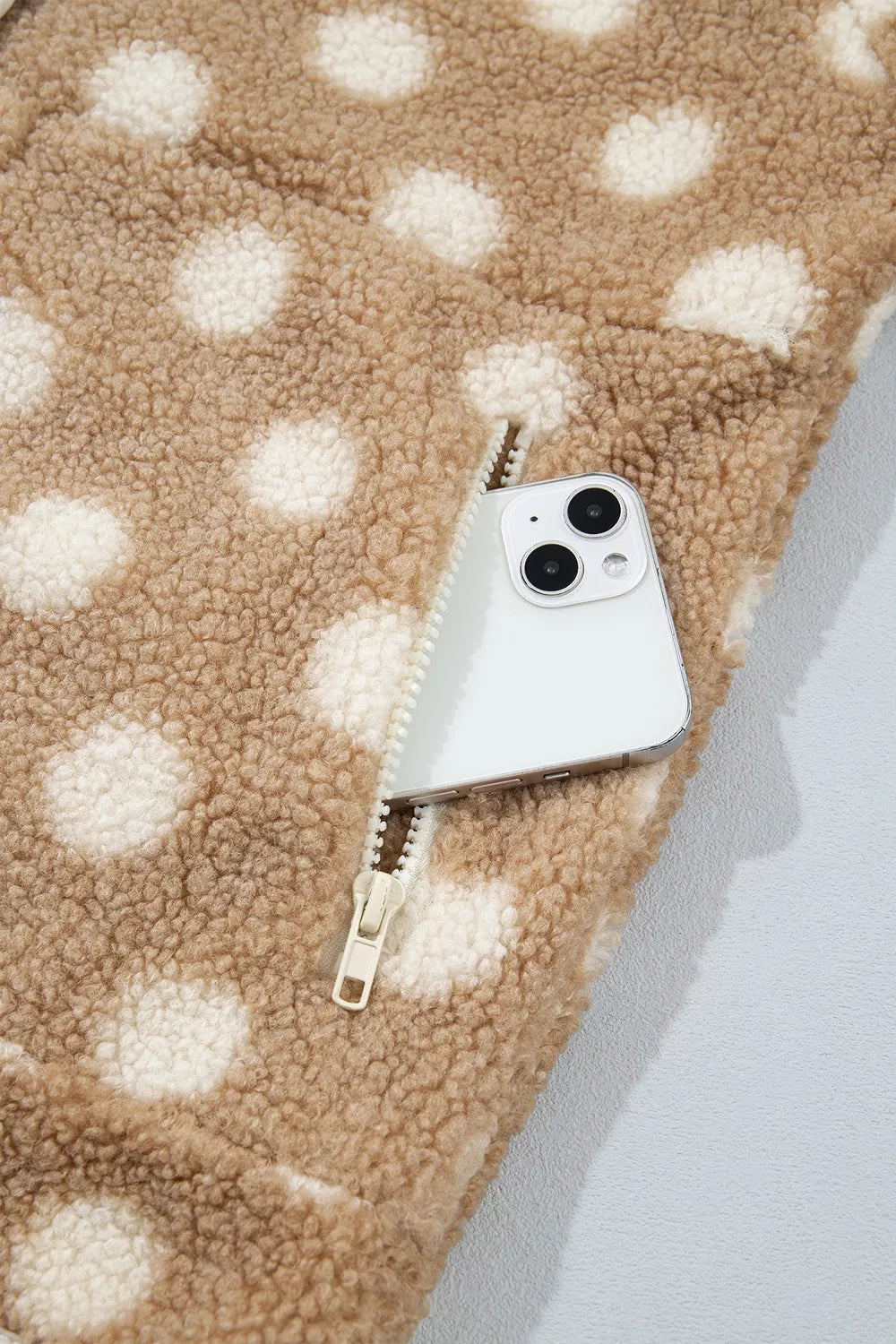 Tan and white polka dot faux fur button-front jacket with zip pockets, open pocket detail