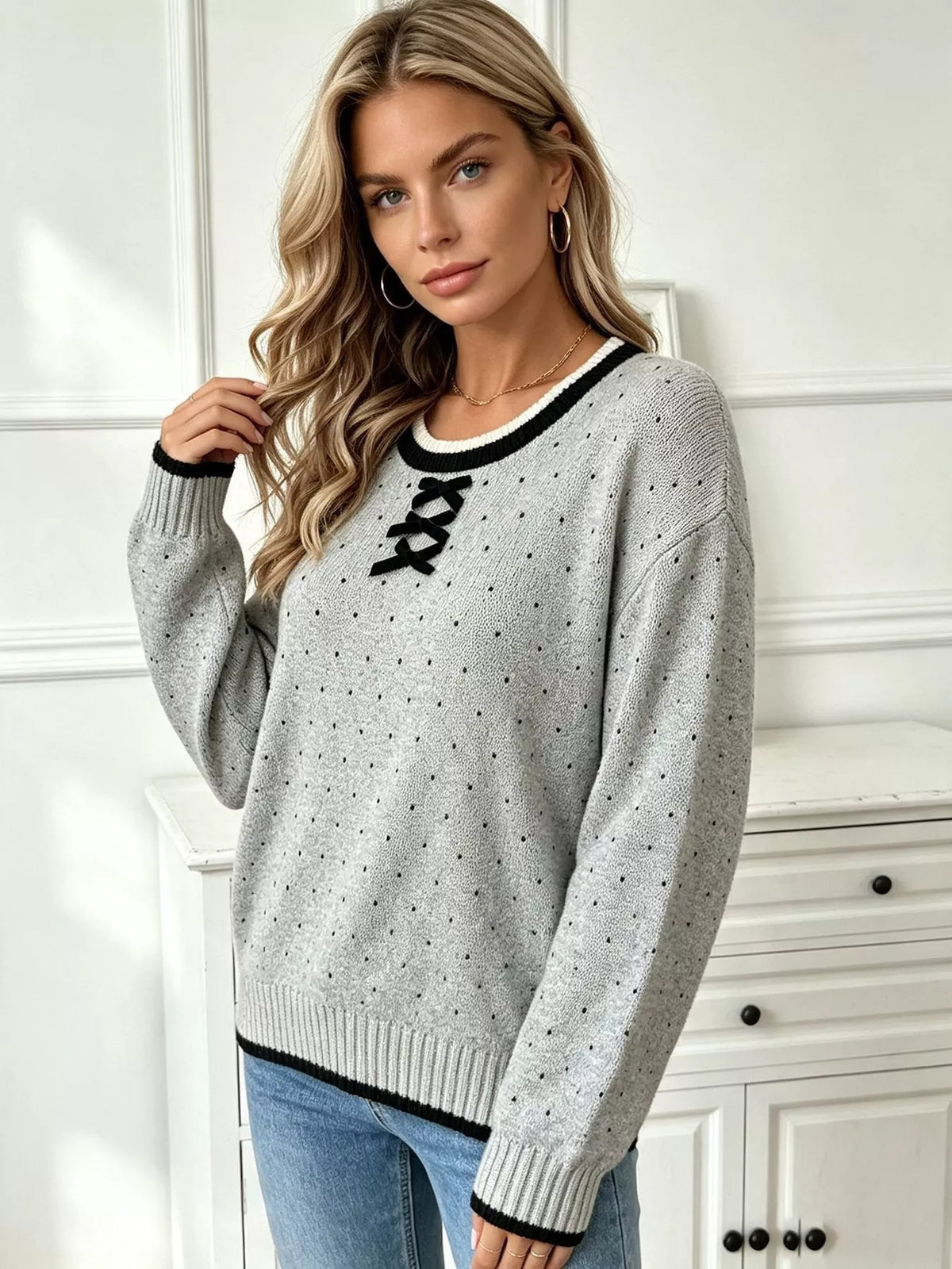 Gray and black polka dot lace-up sweater, front view.