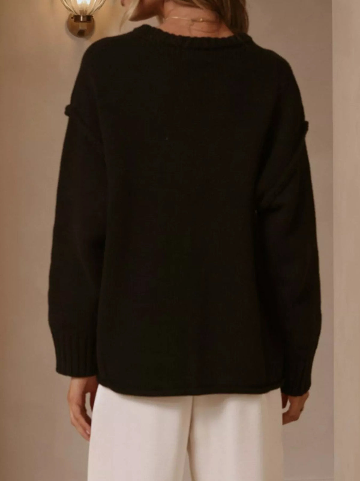 Black crewneck dropped-shoulder sweater, back view.