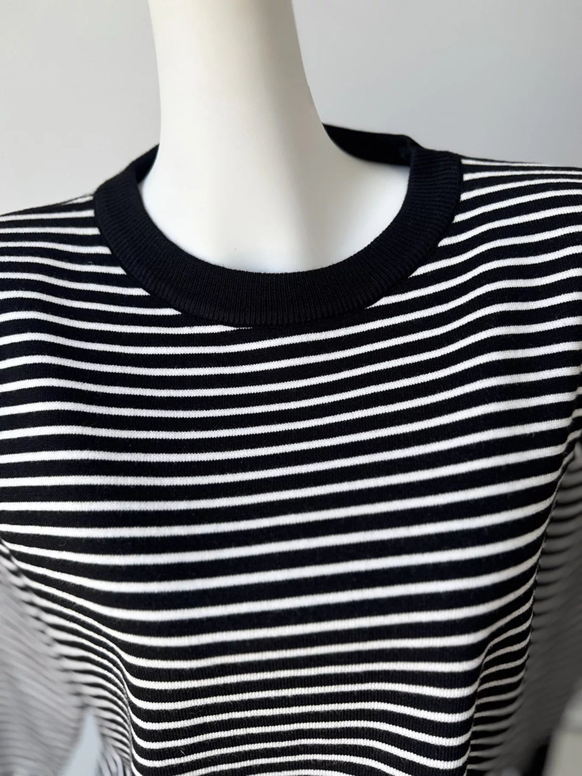 Striped round-neck knit top in black and white, neckline detail