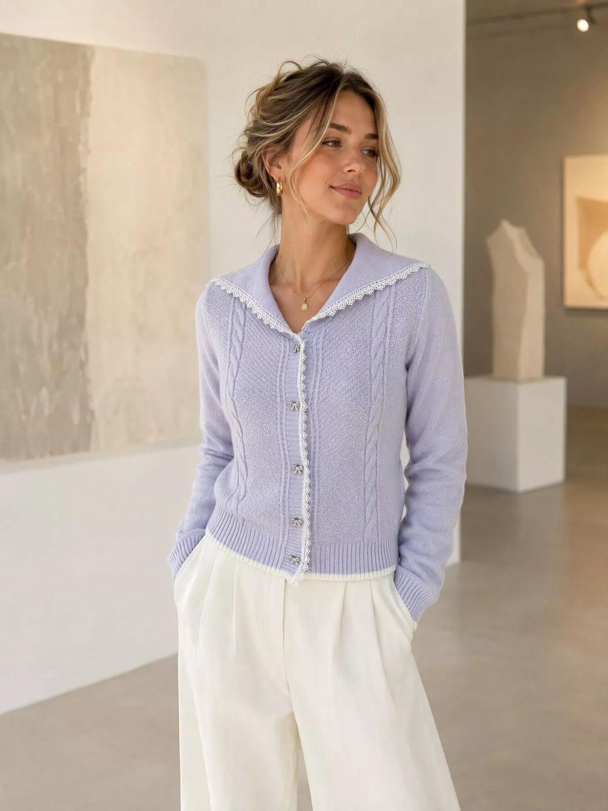 Lavender cable-knit cardigan with lace trim, angled front view.