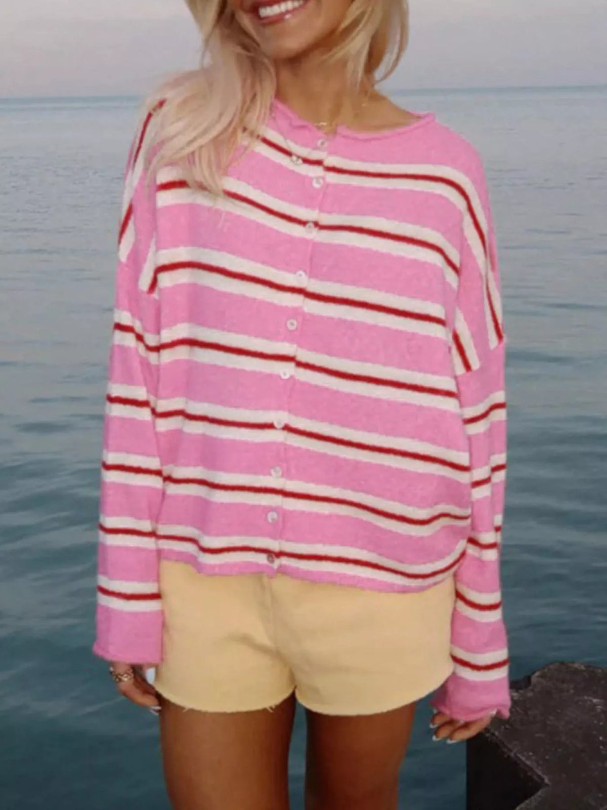 Pink striped button-front cardigan, front view with arms lowered