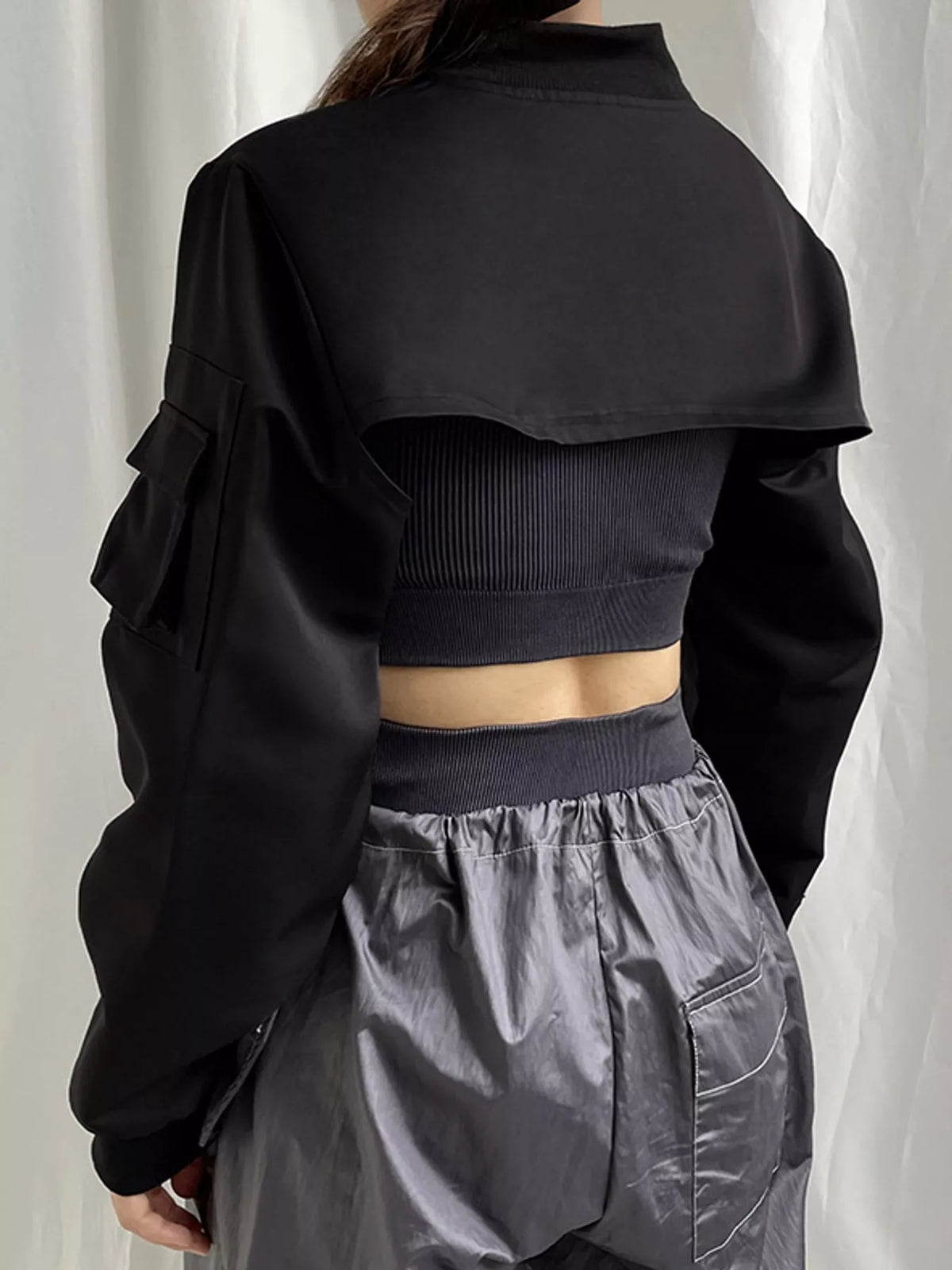 Black ultra-cropped zip-front long sleeve shrug, back view