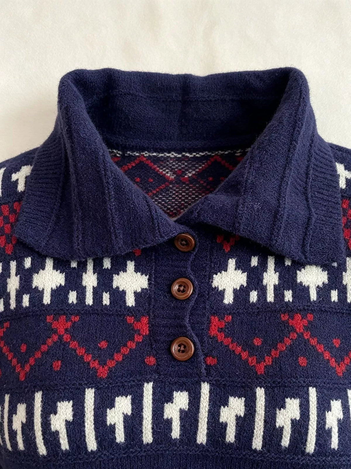 Navy fair isle polo-collar sweater, collar and button detail.