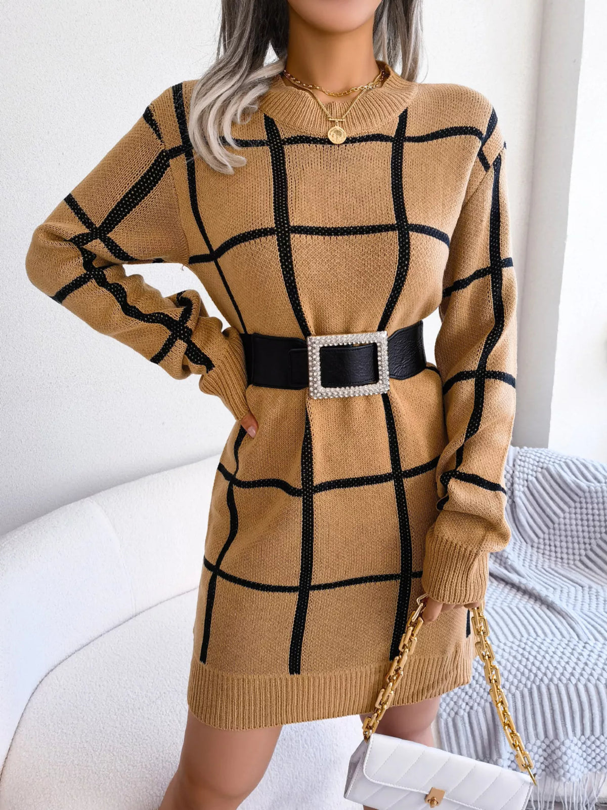 Camel windowpane long-sleeve sweater dress, belted front with hand at waist.