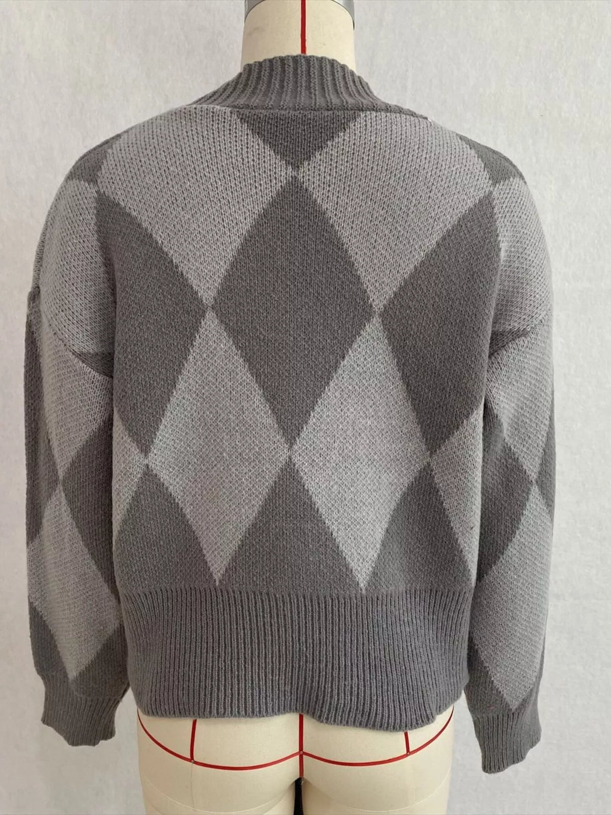 Gray argyle v-neck button-front cardigan, back on dress form.
