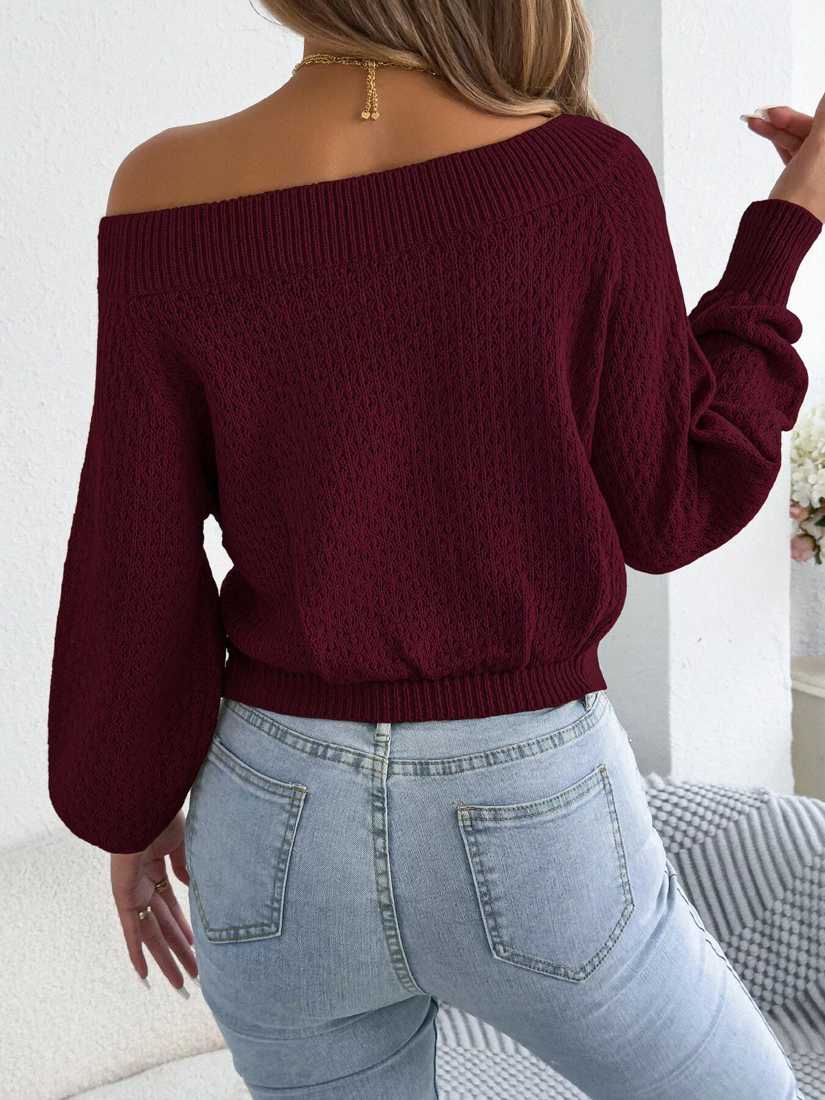 Burgundy off-shoulder twist-front knit sweater, back view.