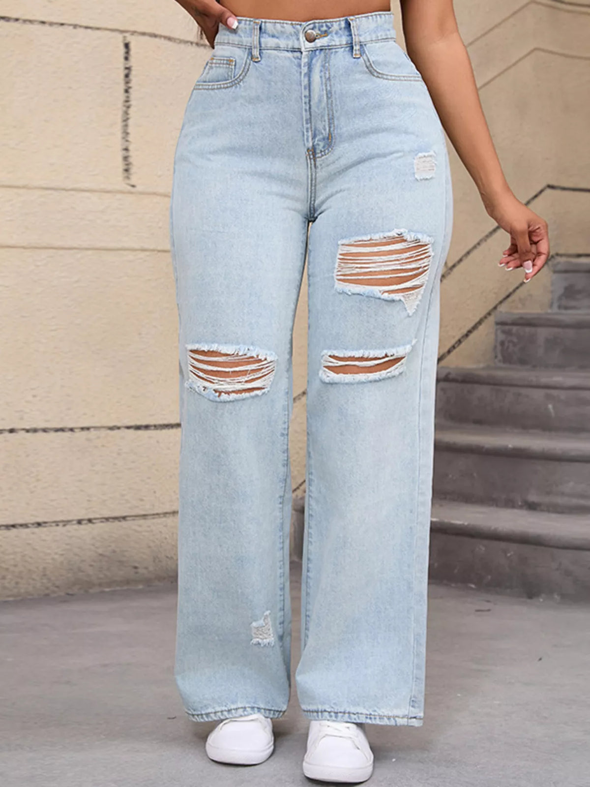 Light blue distressed wide-leg jeans, front leg detail with hand at waist