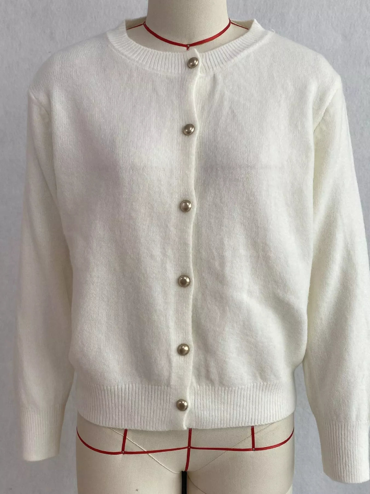 White round-neck button-front knit cardigan, front on dress form.