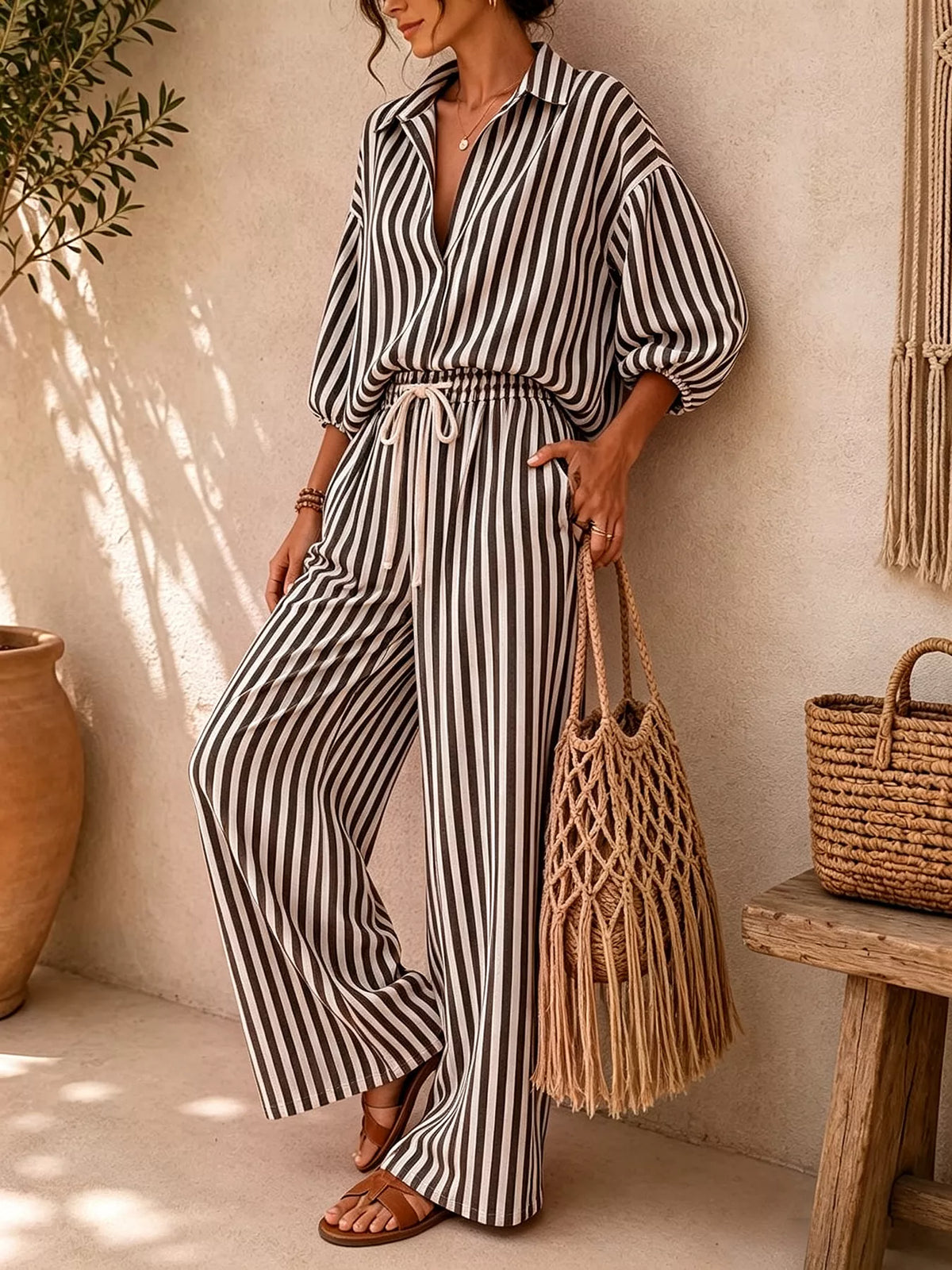 Black and white striped shirt and drawstring pants set, front view with one leg bent
