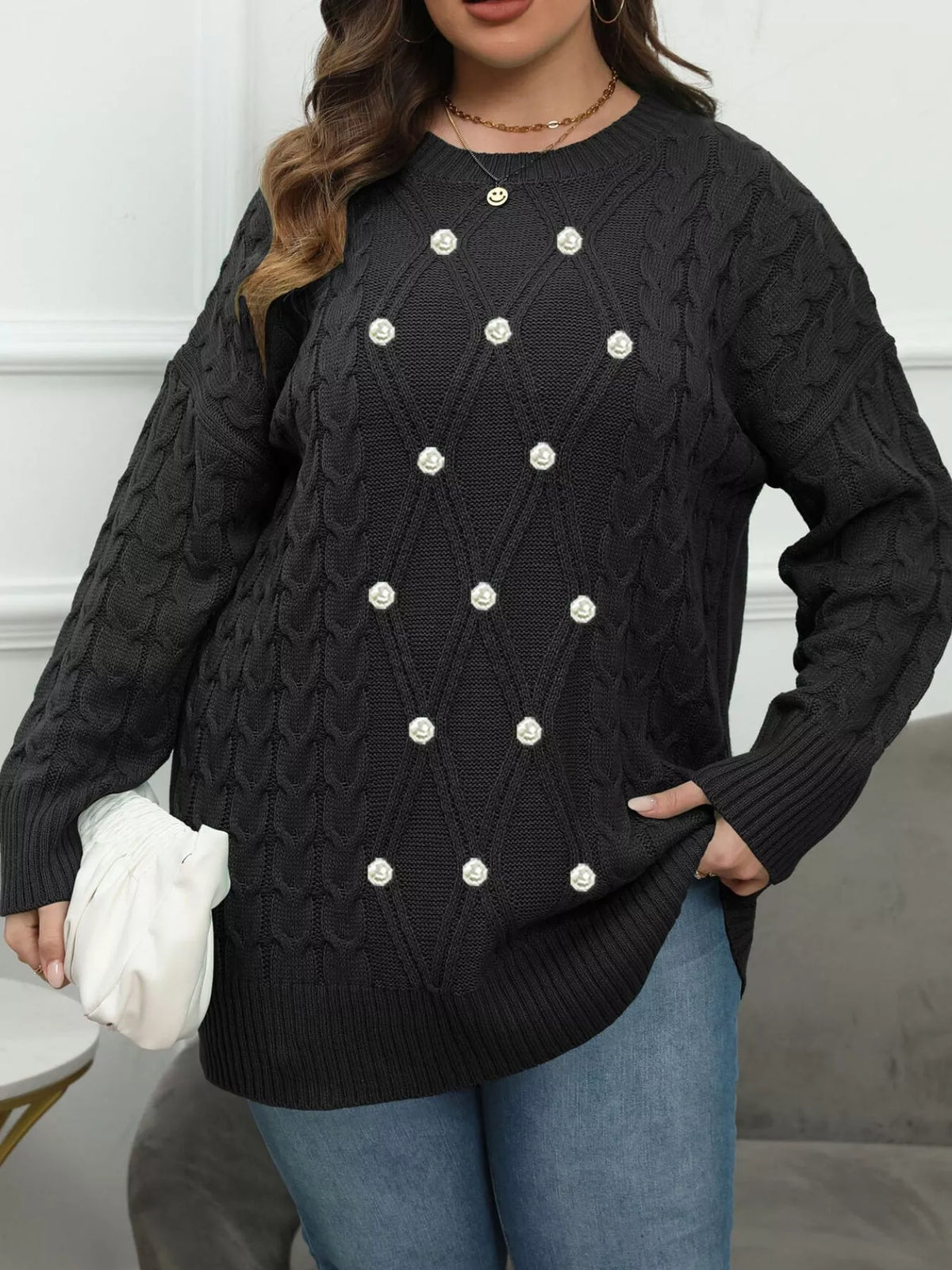 Black plus-size cable-knit sweater with pearl-like front accents, angled front view
