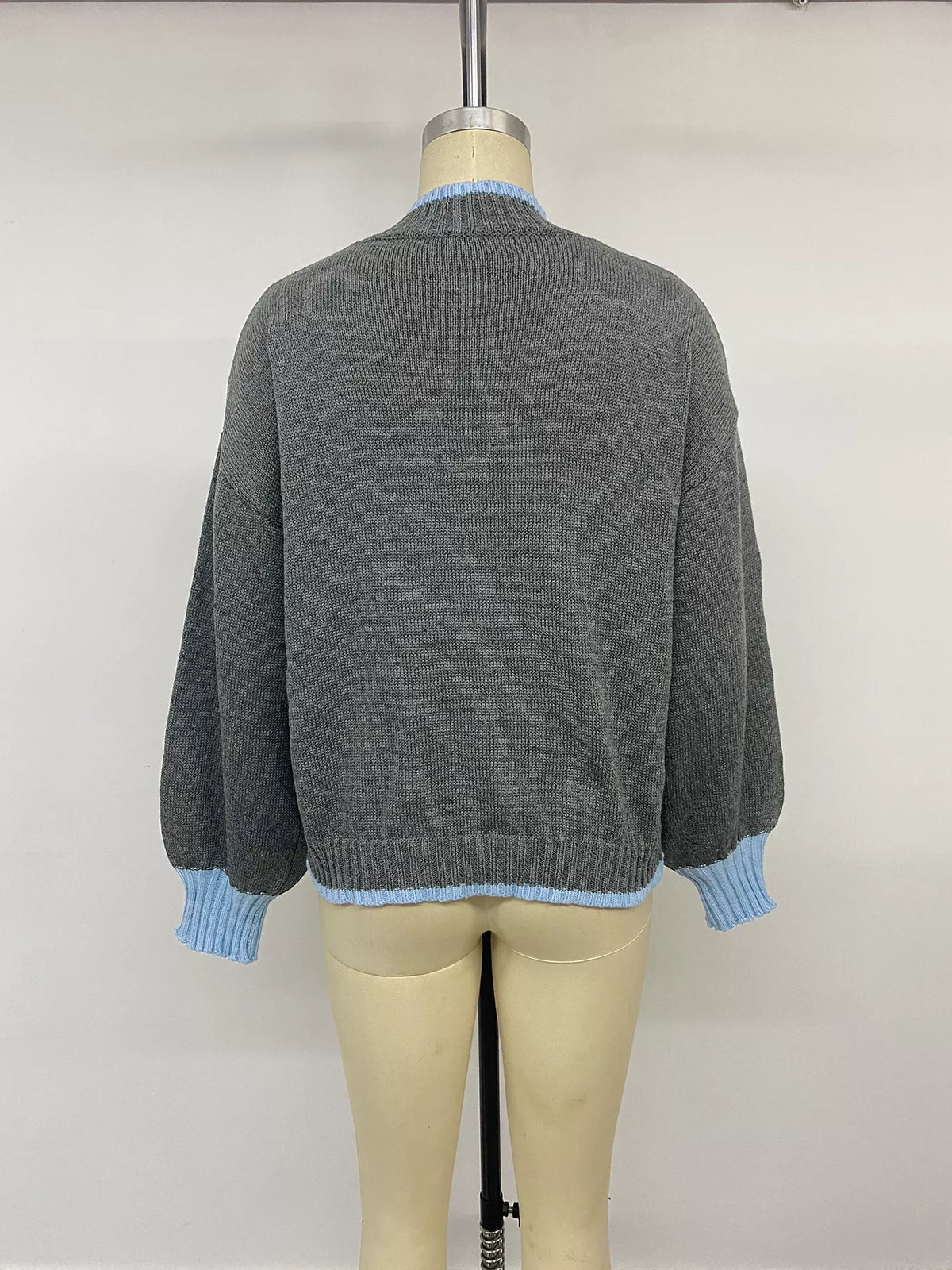 Gray sweater with blue contrast trim, back on mannequin